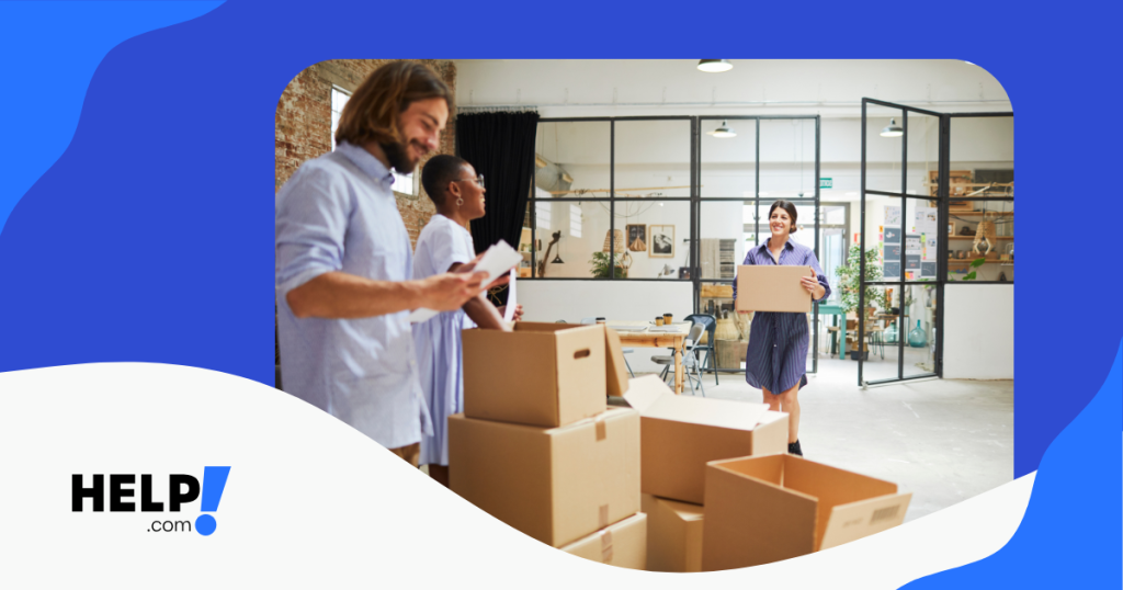 Team of three workers setting up a new business in their office unpacking boxes